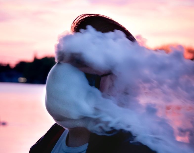 Guy vapeando después de reemplazar los anillos de su cigarrillo electrónico