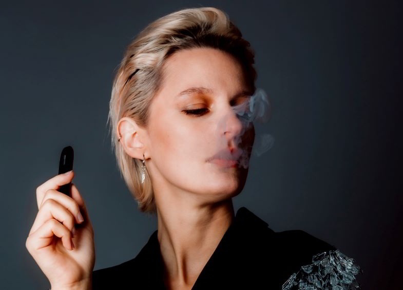 Mujer vaping con un simple cigarrillo electrónico