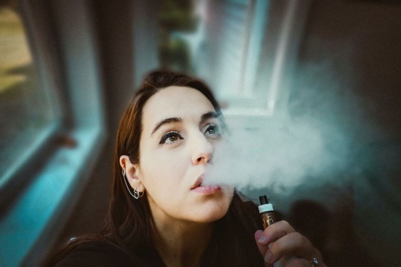 Chica preguntándose para qué es el drip tip de su cigarrillo electrónico