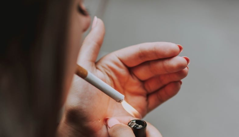 Mujer encendiendo un cigarrillo