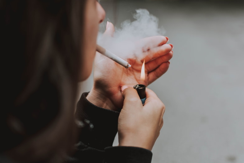 Mujer encendiendo un cigarrillo