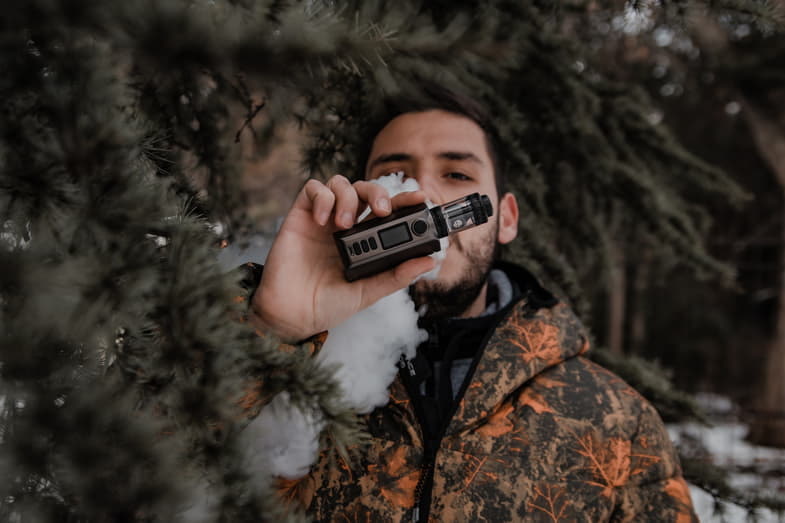 Niño fumando con un moderno cigarrillo electrónico